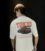 Young boy wearing a T-shirt mentioning tokyo on the back side